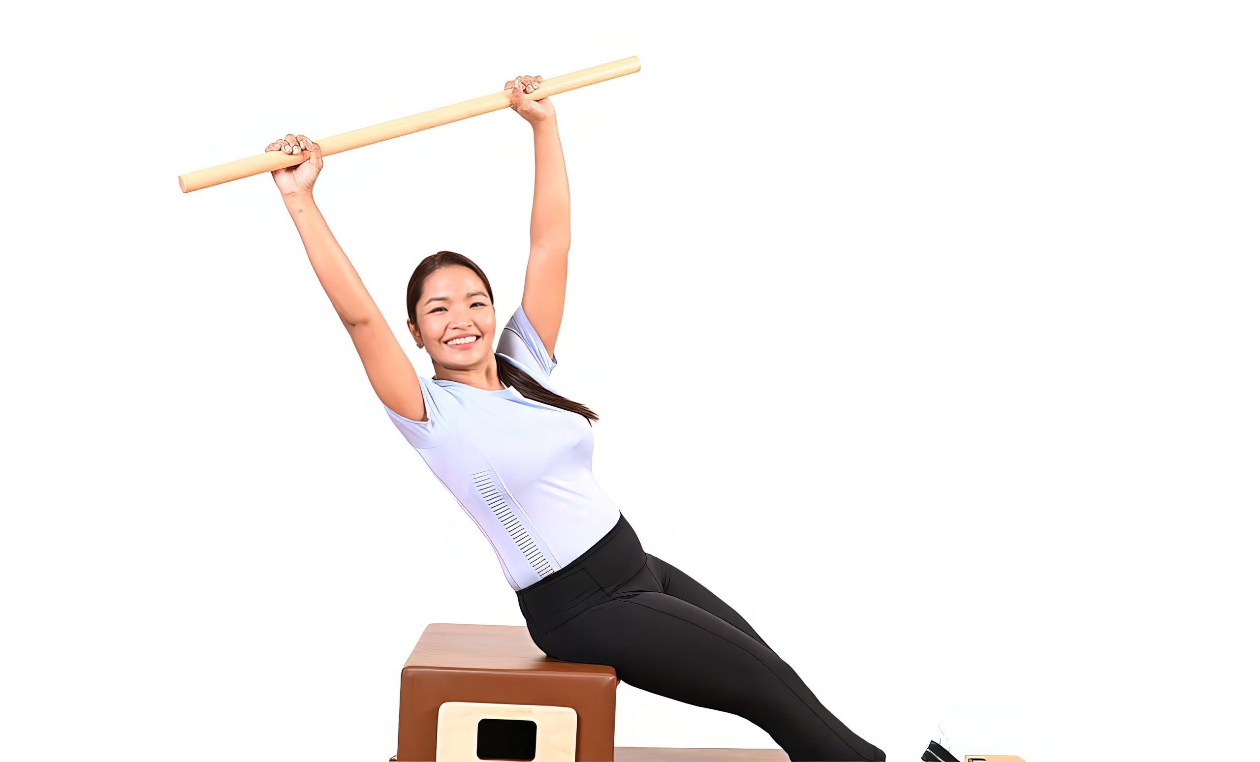 An All Core Pilates Instructor doing a Pilates pose on a Merrithew Reformer exercise machine