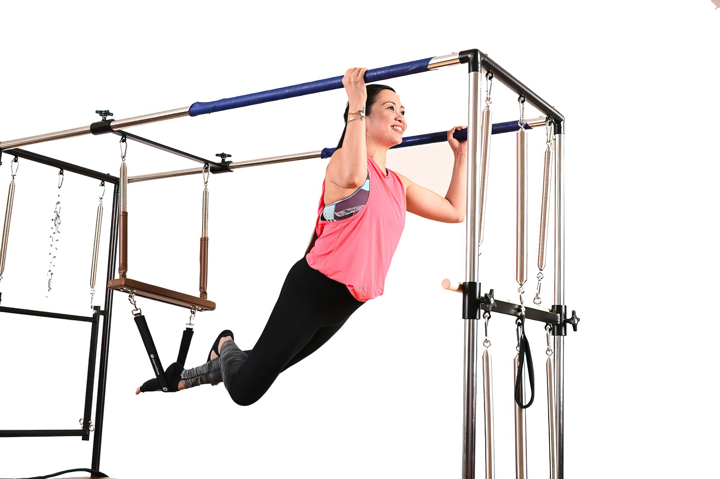 An All Core Pilates Instructor doing a Pilates pose on a Cadillac Reformer exercise machine
